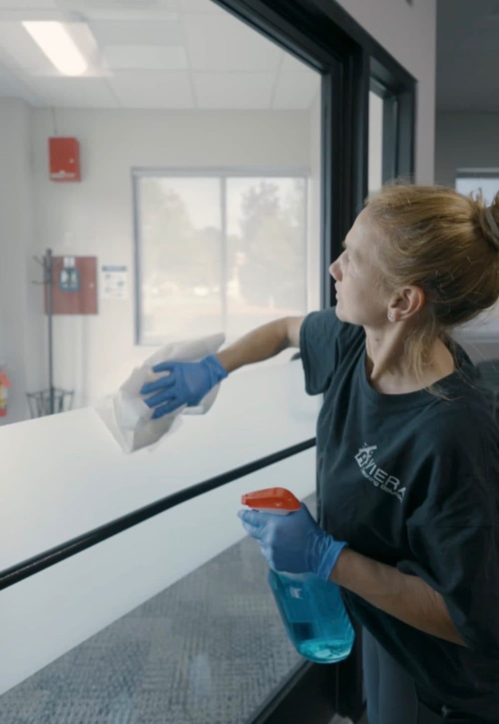 Viera Cleaning Solutions team member cleaning interior office glass